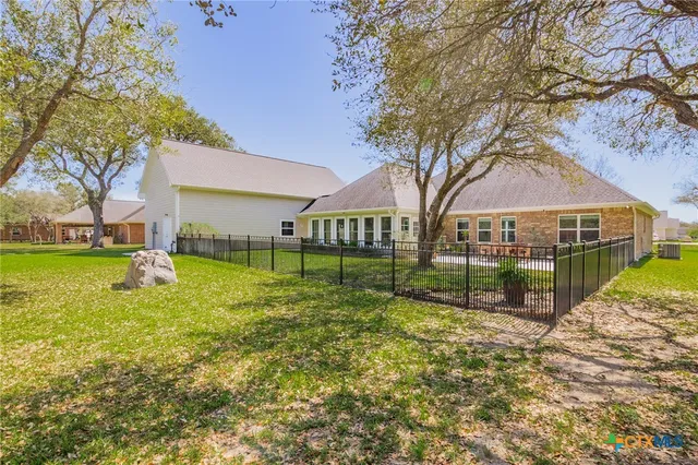 a view of backyard of house with trees and green space