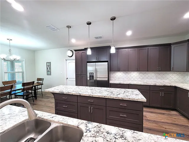 a kitchen with granite countertop stainless steel appliances and wooden cabinets