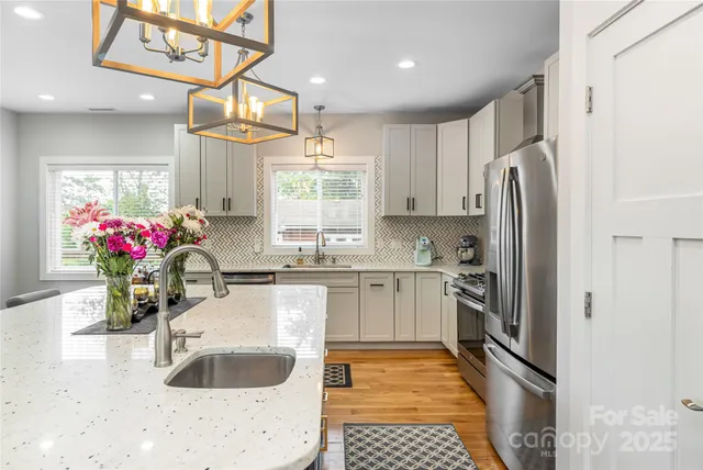 a kitchen with granite countertop a sink stainless steel appliances and cabinets