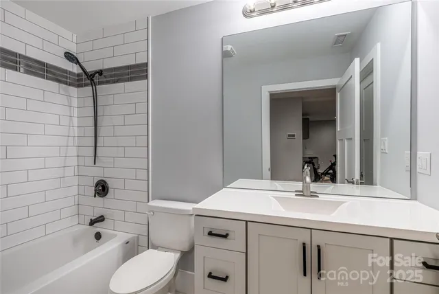 a bathroom with a sink toilet vanity and shower