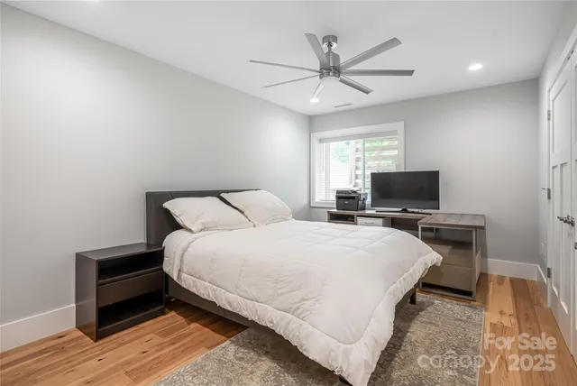 a bedroom with a bed and a flat screen tv