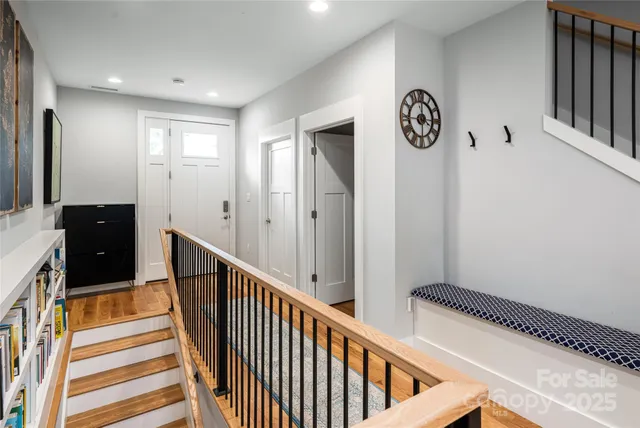 a view of a hallway with wooden floor and entryway