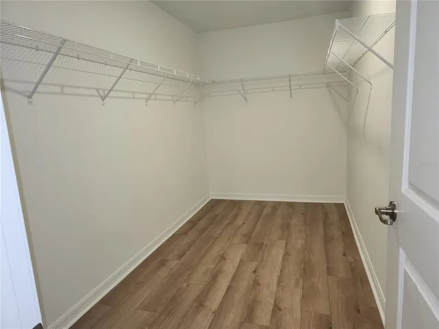 an empty room with wooden floor and cabinet