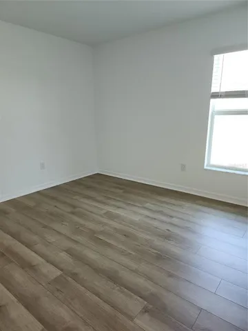 a view of a hallway with wooden floor and closet
