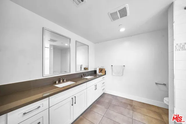 a spacious bathroom with a sink and a mirror