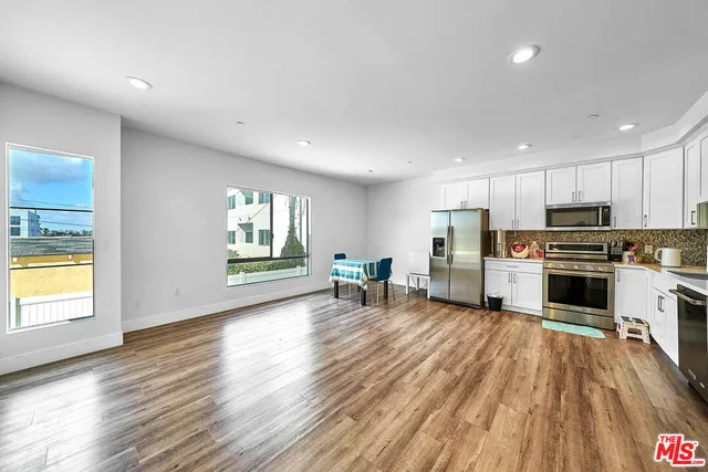 a kitchen with wooden floors and white appliances
