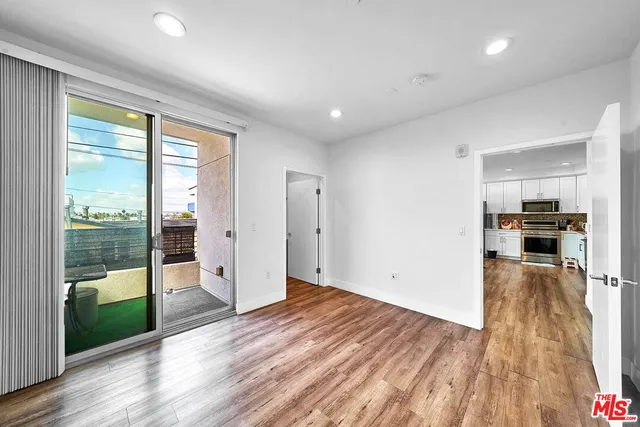 a view of a kitchen with wooden floor and a window