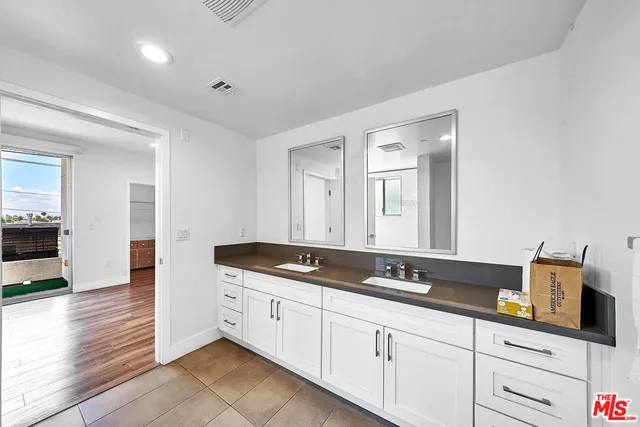 a spacious bathroom with a granite countertop sink and a mirror