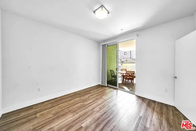 an empty room with wooden floor and a window