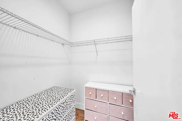 a view of a closet area with wooden floor