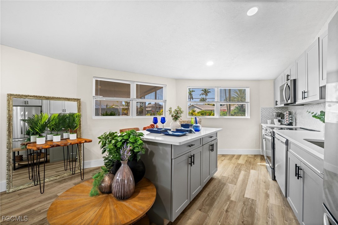 190 Tarpon Road Fort Myers Beach, FL 33931 - Photo 13 of 47 a kitchen with stainless steel appliances granite countertop a stove a sink dishwasher and a refrigerator with wooden floor