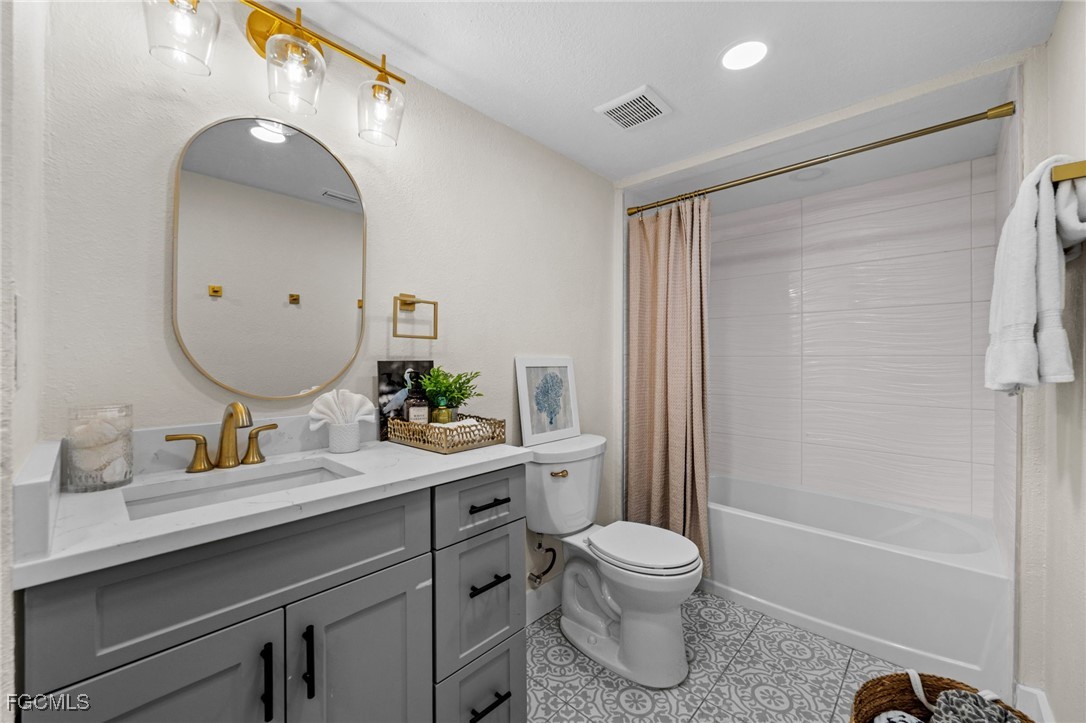 190 Tarpon Road Fort Myers Beach, FL 33931 - Photo 24 of 47 a bathroom with a granite countertop sink toilet a large mirror a bathtub and shower