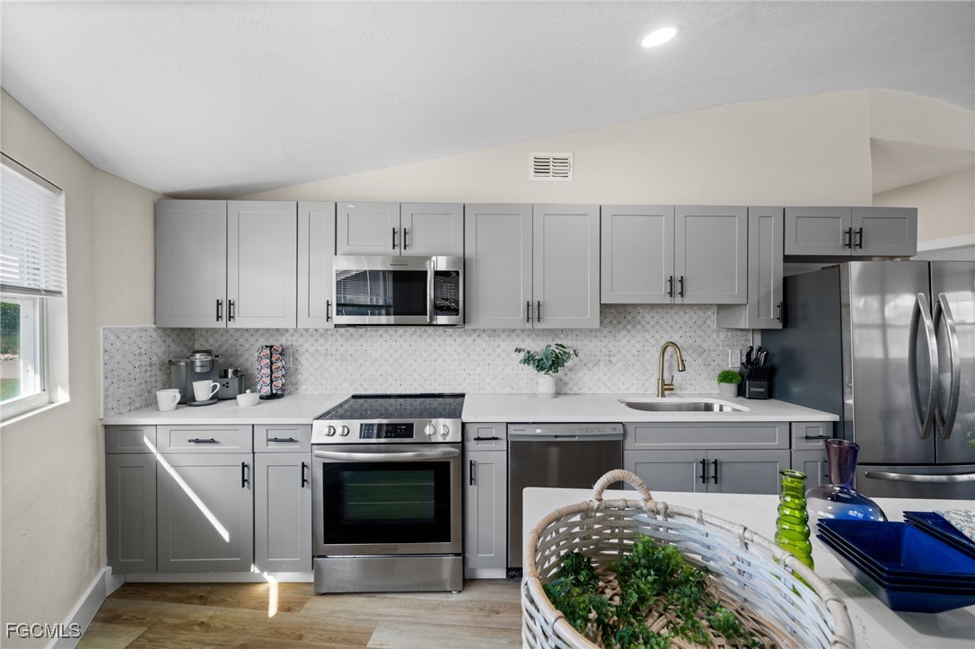 190 Tarpon Road Fort Myers Beach, FL 33931 - Photo 8 of 47 a kitchen with stainless steel appliances kitchen island granite countertop a stove a sink dishwasher and a refrigerator with wooden cabinets