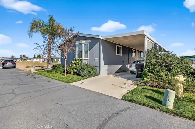 a front view of a house with a yard and potted plants
