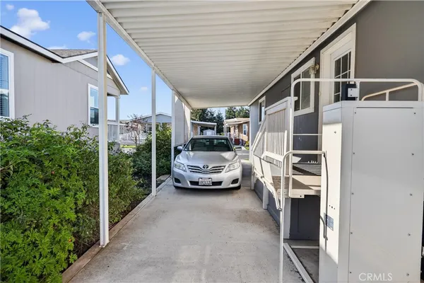 a yellow house with potted plants in front of door