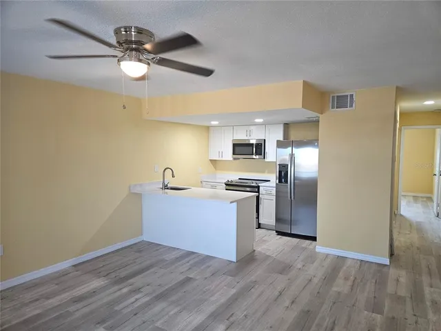 a kitchen with granite countertop white cabinets and stainless steel appliances