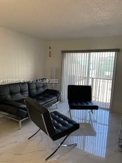 6965 Harding Avenue, Unit 406 Miami Beach, FL 33141 - Photo 2 of 10 a living room with furniture a flat screen tv and a fireplace