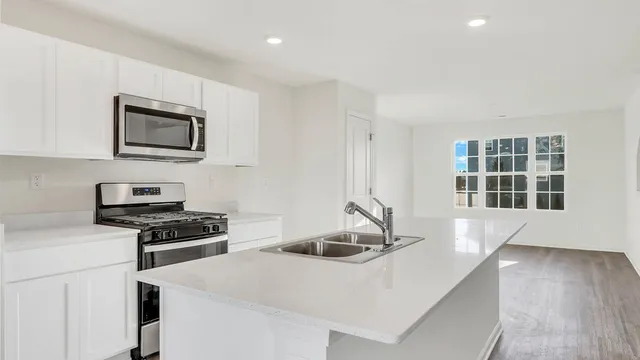 a kitchen with granite countertop a stove and a sink