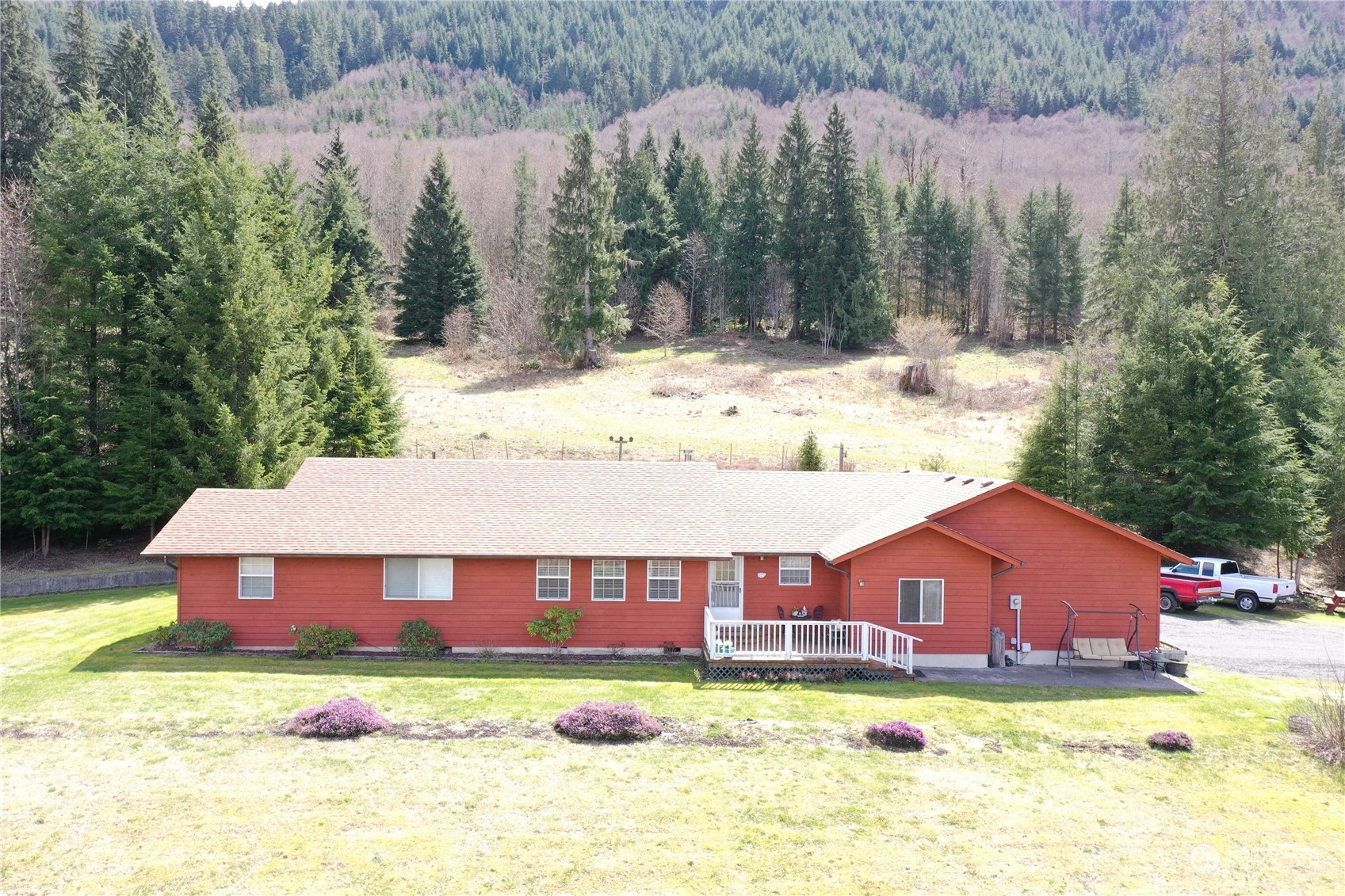 a view of a house with a yard covered in the forest