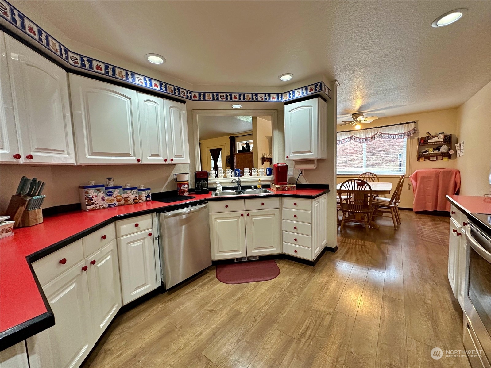 104 Compton Road Morton, WA 98356 - Photo 12 of 35 a kitchen with stainless steel appliances granite countertop a stove a sink dishwasher and cabinets with wooden floor