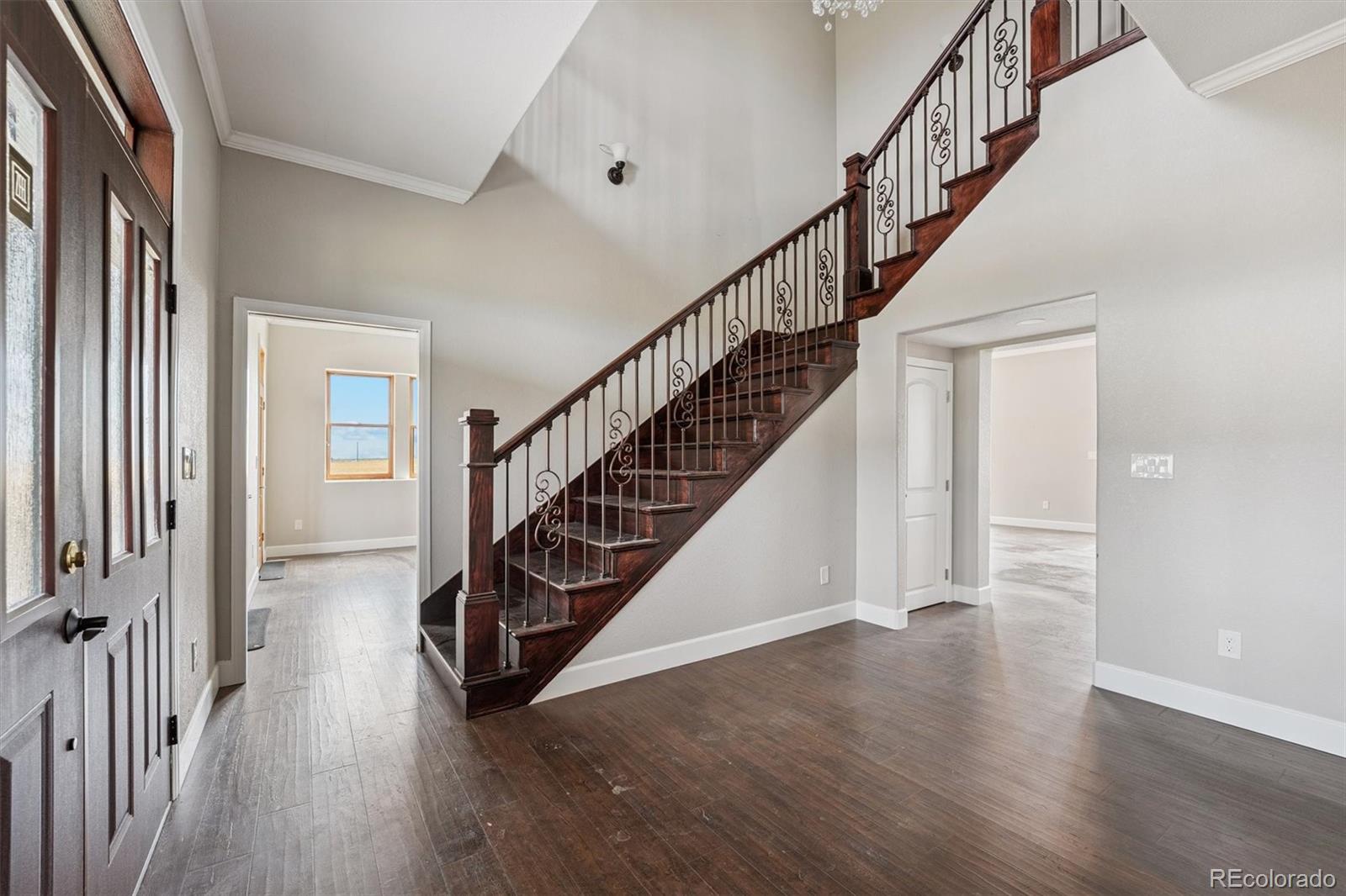 2105 Timberlake Road Byers, CO 80103 - Photo 19 of 48 a view of staircase with wooden floor and a chandelier