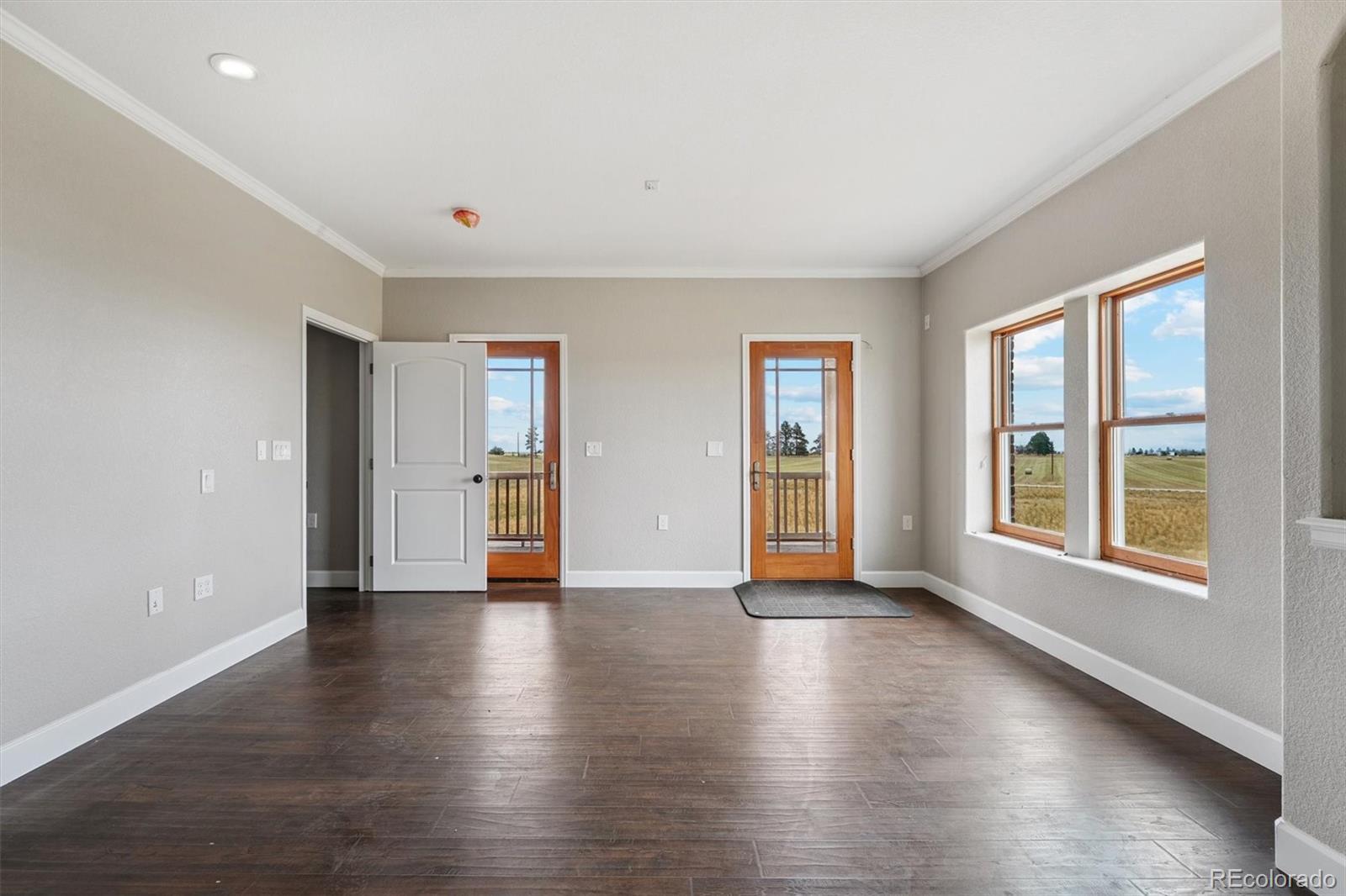 2105 Timberlake Road Byers, CO 80103 - Photo 21 of 48 an empty room with wooden floor and windows