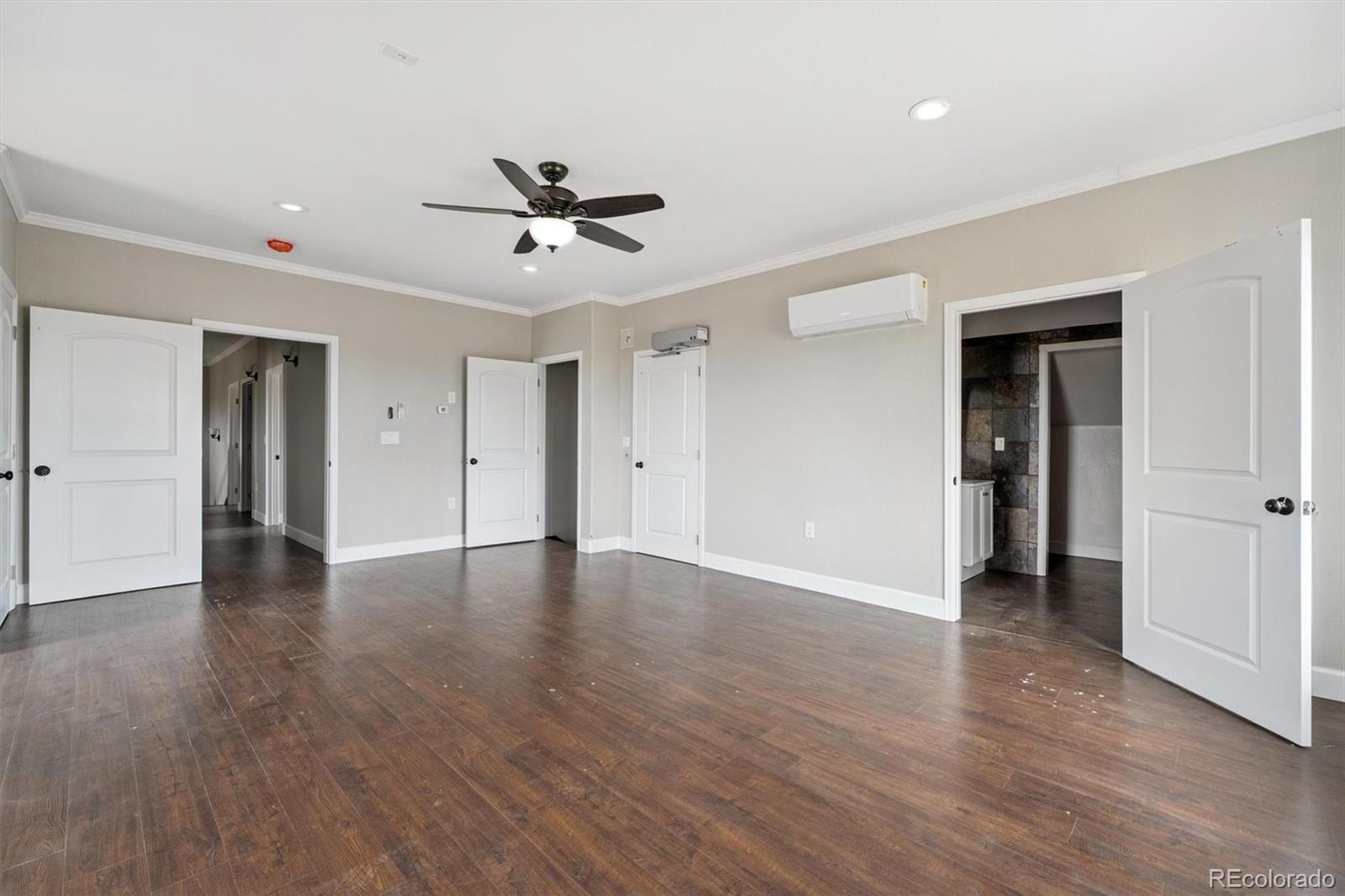 2105 Timberlake Road Byers, CO 80103 - Photo 29 of 48 a view of an empty room with wooden floor and a ceiling fan