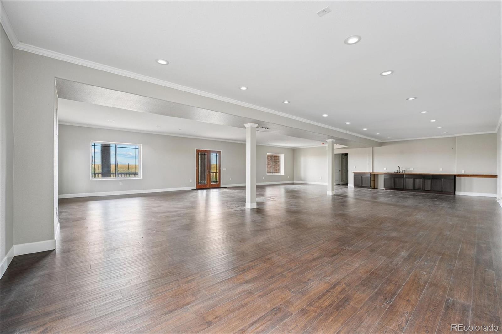 2105 Timberlake Road Byers, CO 80103 - Photo 34 of 48 a view of empty room with wooden floor and kitchen