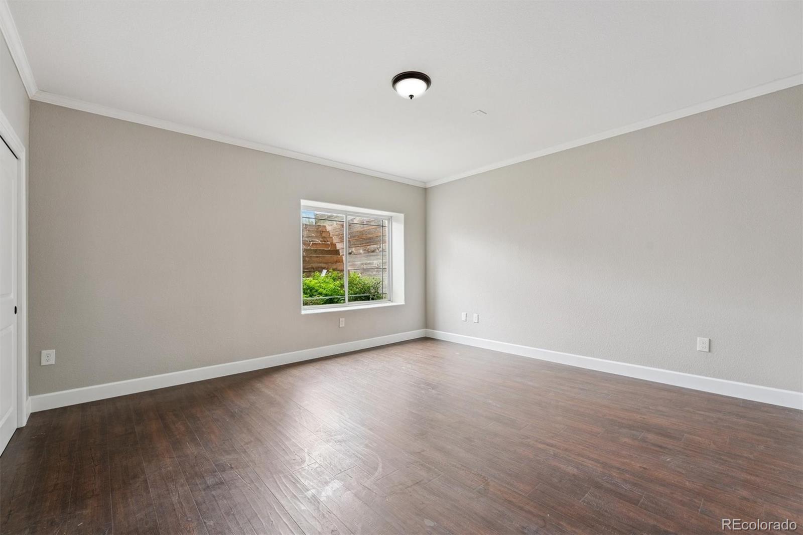 2105 Timberlake Road Byers, CO 80103 - Photo 35 of 48 a view of an empty room with wooden floor and a window