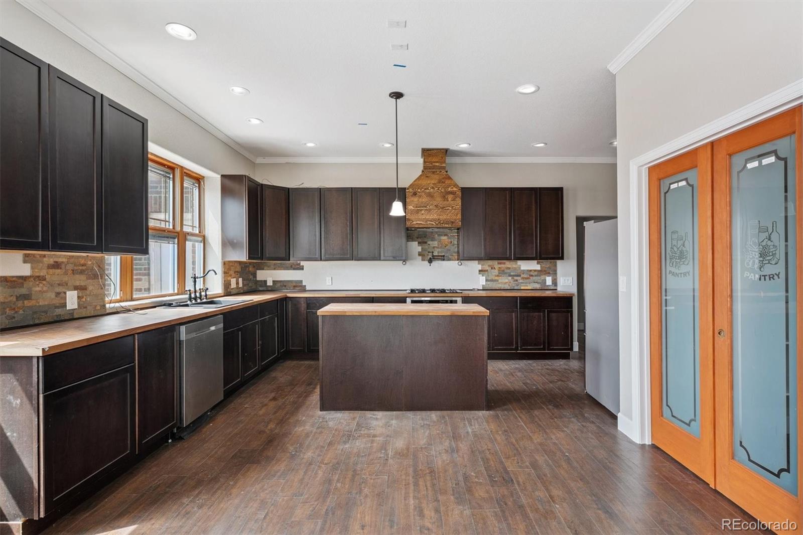 2105 Timberlake Road Byers, CO 80103 - Photo 4 of 48 a large kitchen with stainless steel appliances granite countertop a stove a sink dishwasher and a refrigerator with wooden floor