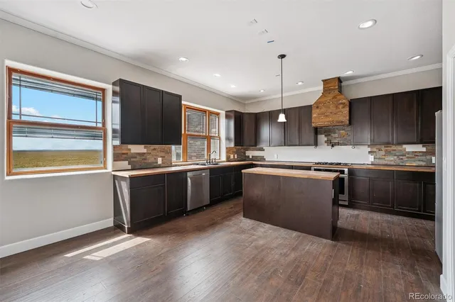 a kitchen with stainless steel appliances kitchen island granite countertop a stove a sink and a microwave