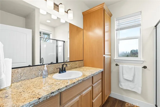 a bathroom with a granite countertop sink and a mirror