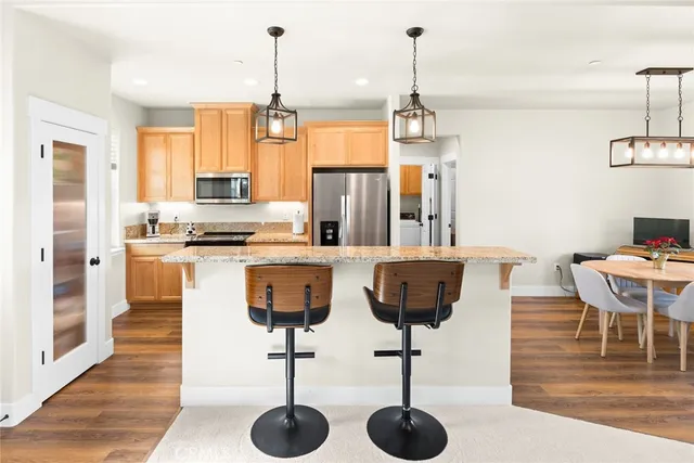 a kitchen with stainless steel appliances kitchen island granite countertop a table and chairs