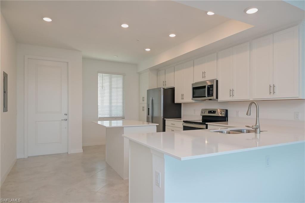 5835 Double Eagle Circle, Unit 4724 Immokalee, FL 34142 - Photo 6 of 25 a kitchen with stainless steel appliances a microwave a sink and cabinets