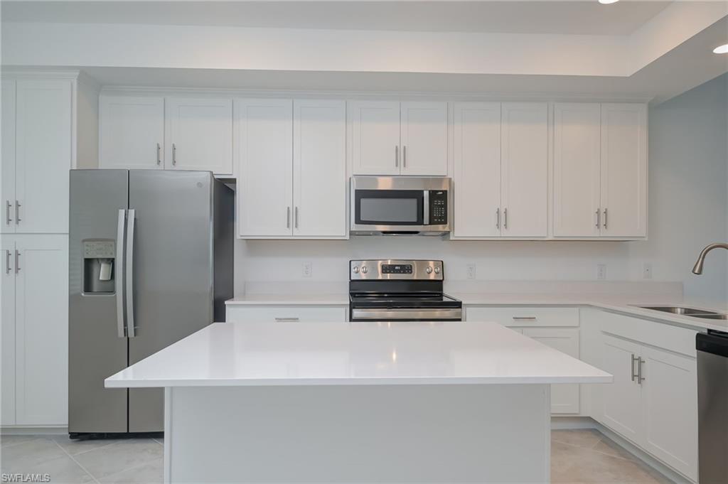 5835 Double Eagle Circle, Unit 4724 Immokalee, FL 34142 - Photo 8 of 25 a kitchen with stainless steel appliances a refrigerator sink and microwave