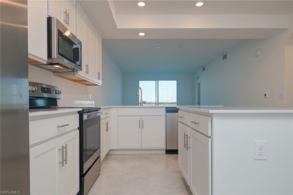 5835 Double Eagle Circle, Unit 4724 Immokalee, FL 34142 - Photo 9 of 25 a kitchen with white cabinets and white appliances