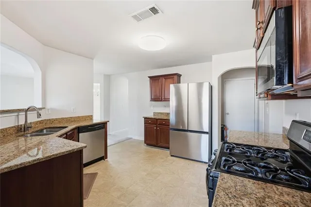 a kitchen with stainless steel appliances granite countertop a refrigerator and a sink