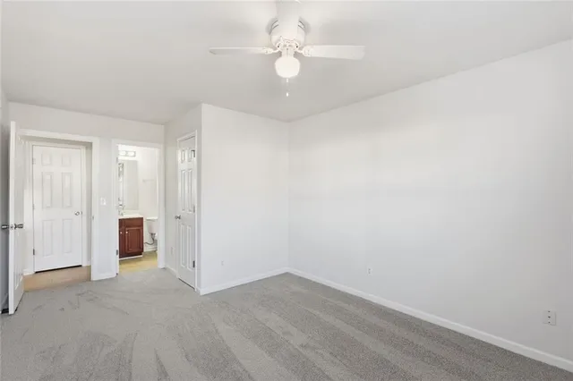 an empty room with a ceiling fan and a window