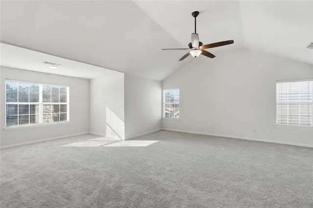 an empty room with fan and windows