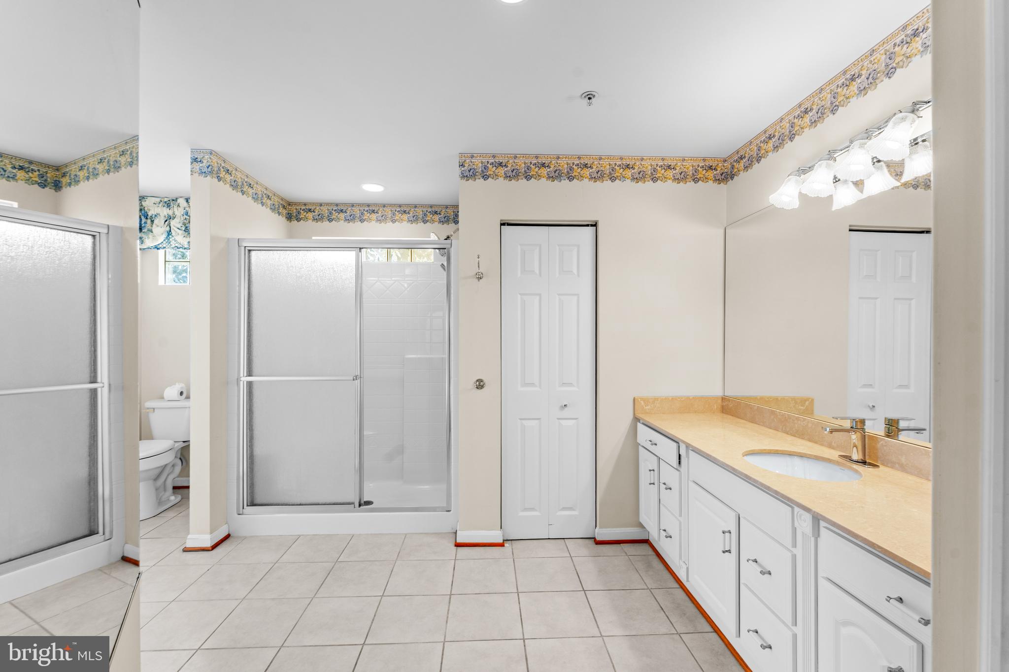 11709 Thrift Road Clinton, MD 20735 - Photo 29 of 71 a spacious bathroom with a granite countertop sink a mirror and a shower