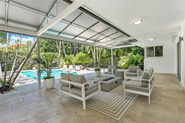 a view of backyard with swimming pool and seating