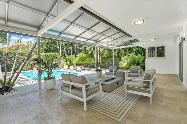 a view of backyard with swimming pool and seating