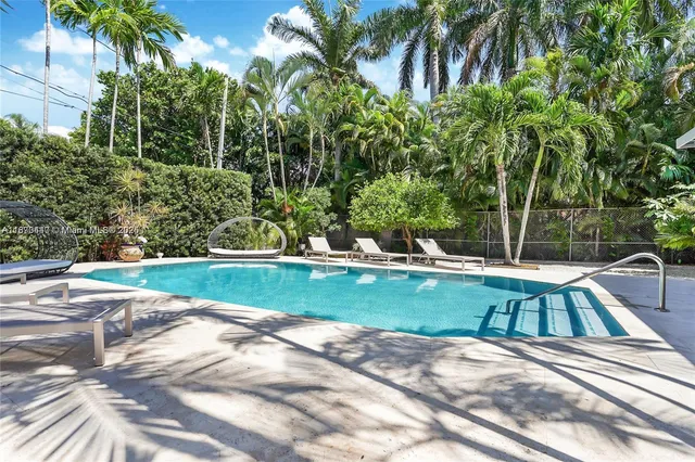 a view of a house with swimming pool and sitting area