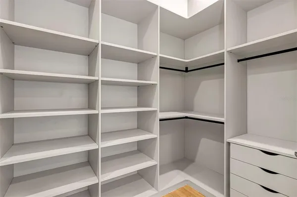 a view of walk in closet with empty racks