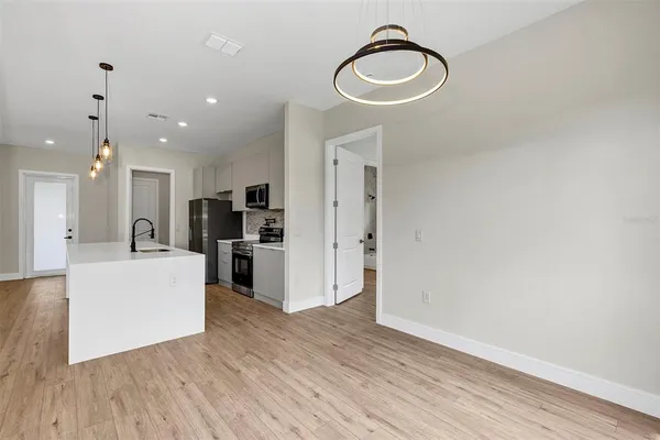 a kitchen with stainless steel appliances granite countertop a sink a kitchen island with wooden cabinets and wooden floor