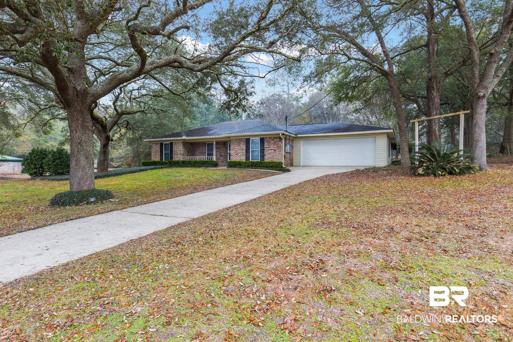 7345 Spaceview Drive Saraland, AL 36571 - Photo 2 of 22 Ranch-style house with driveway, a garage, brick siding, and a front lawn