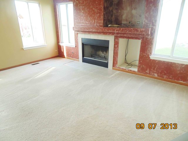 637 Deames Street Plano, IL 60545 - Photo 7 of 18 an empty room with windows and fireplace