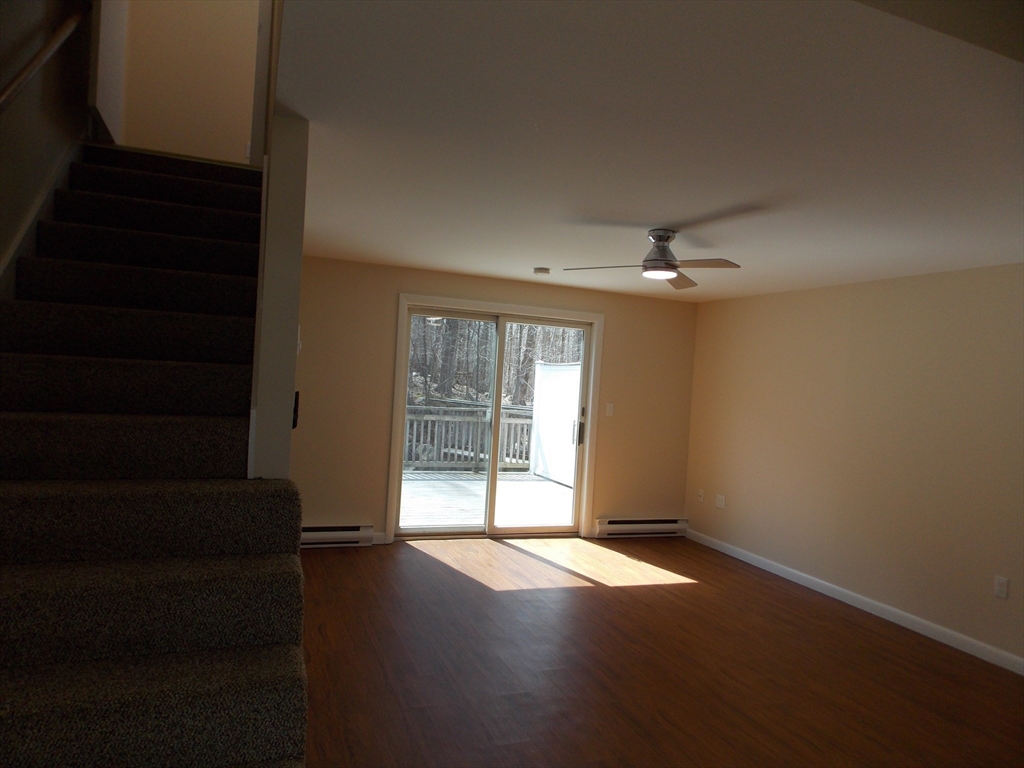 196 Main Street, Unit A Rockport, MA 01966 - Photo 12 of 36 a view of an empty room with wooden floor and a window