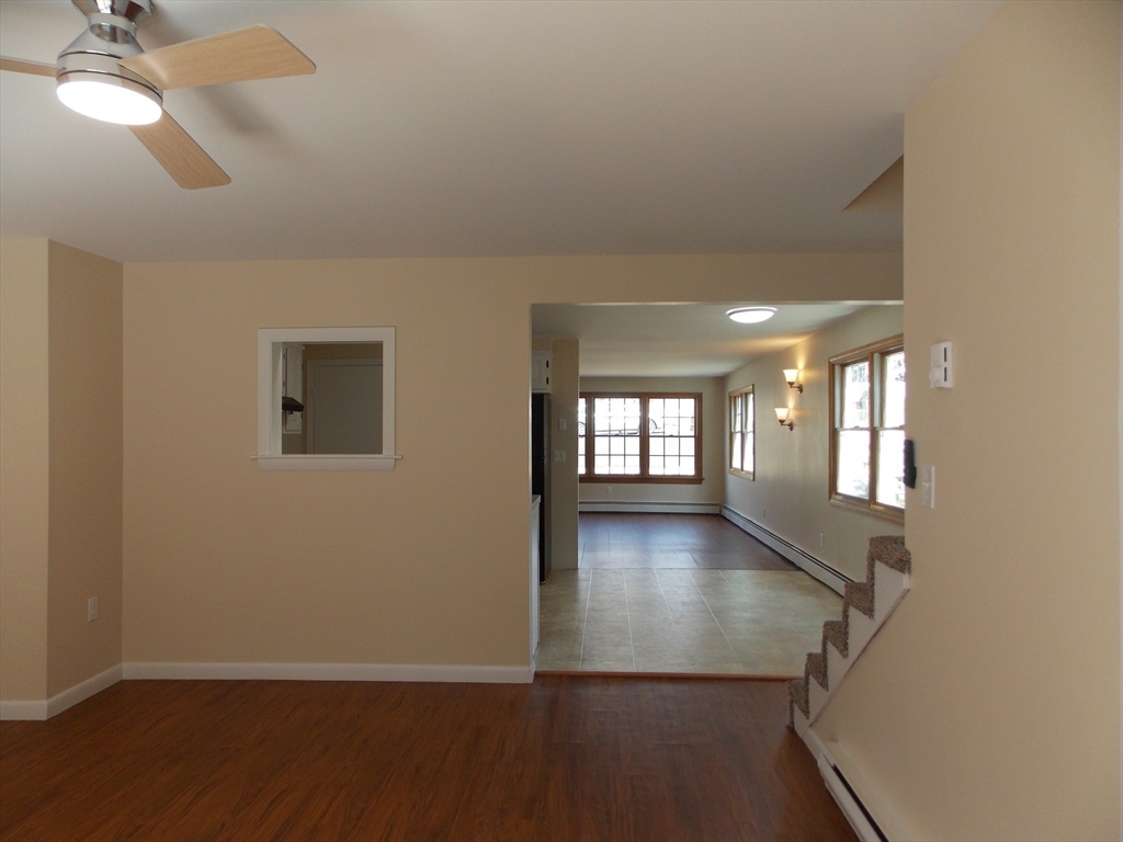 196 Main Street, Unit A Rockport, MA 01966 - Photo 14 of 36 an empty room with wooden floor and windows