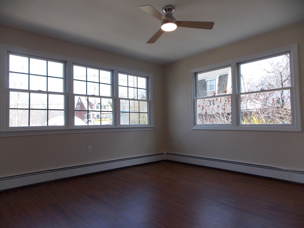 196 Main Street, Unit A Rockport, MA 01966 - Photo 15 of 36 a view of an empty room with wooden floor and a window